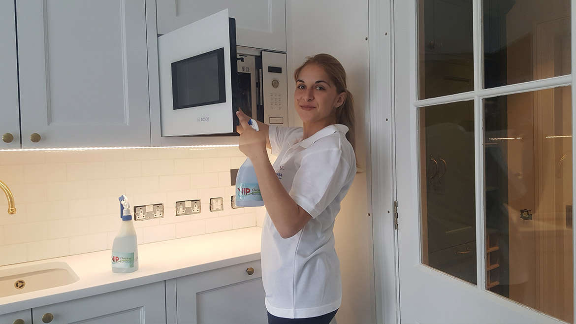 Our girl cleaner in kitchen cleaning the microwave